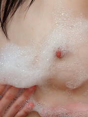Little teen girl plays with her body in the bubble bath