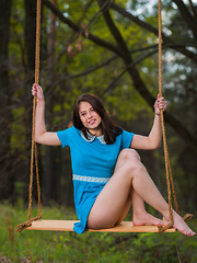 Hilary C playfully poses outdoors baring her slender body on the swing.