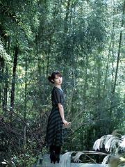 Neo Asian in long dress goes to enjoy reading book in the forest